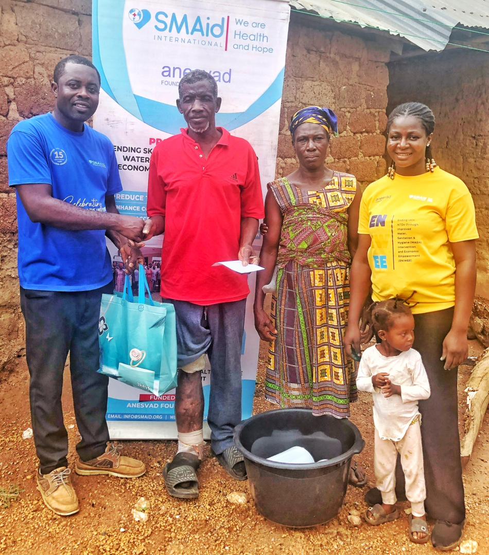 SMAid staff handing over items to Mr. Kwame Nyarko-NTD beneficiary at Nfordwo
